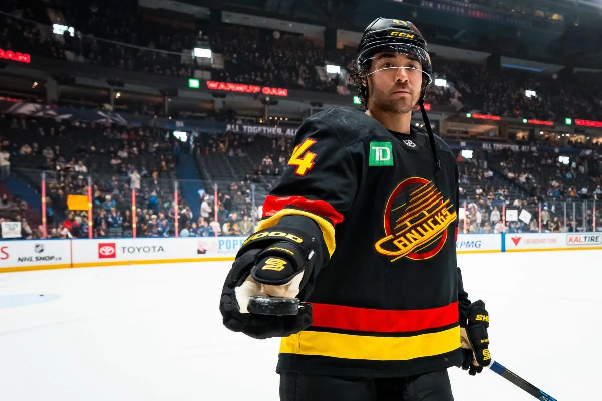 Vancouver Canucks forward Kiefer Sherwood (44) passes a puck to a fan in warm up prior to a game against the Boston Bruins at Rogers Arena.