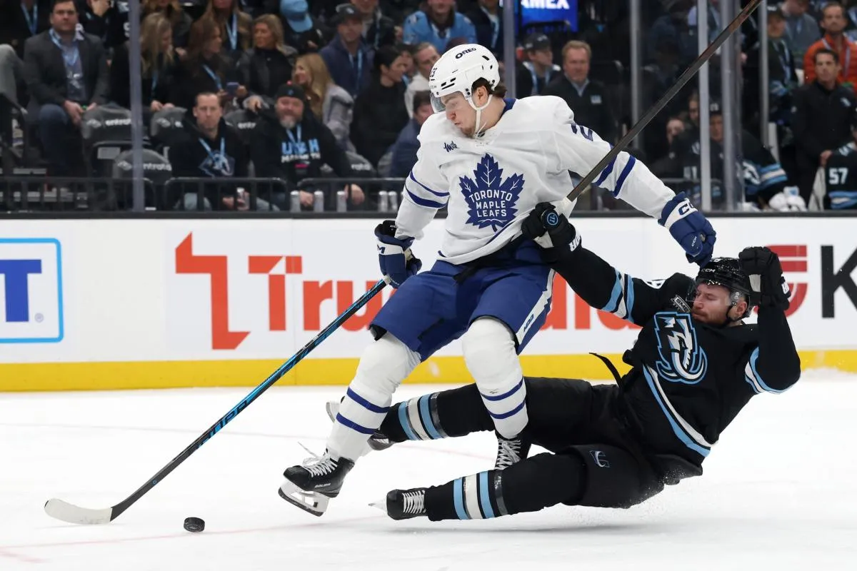 Toronto Maple Leafs left wing Matthew Knies (23) and Utah Mammoth defenseman Ian Cole (28) battle for the puck during the third period at Delta Center.
