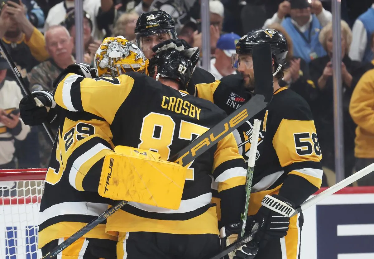 Pittsburgh Penguins goaltender Marc-Andre Fleury (29) is embraced by center Evgeni Malkin (71) and center Sidney Crosby (87) and defenseman Kris Letang (58) after his final NHL game to defeat the Columbus Blue Jackets at PPG Paints Arena.