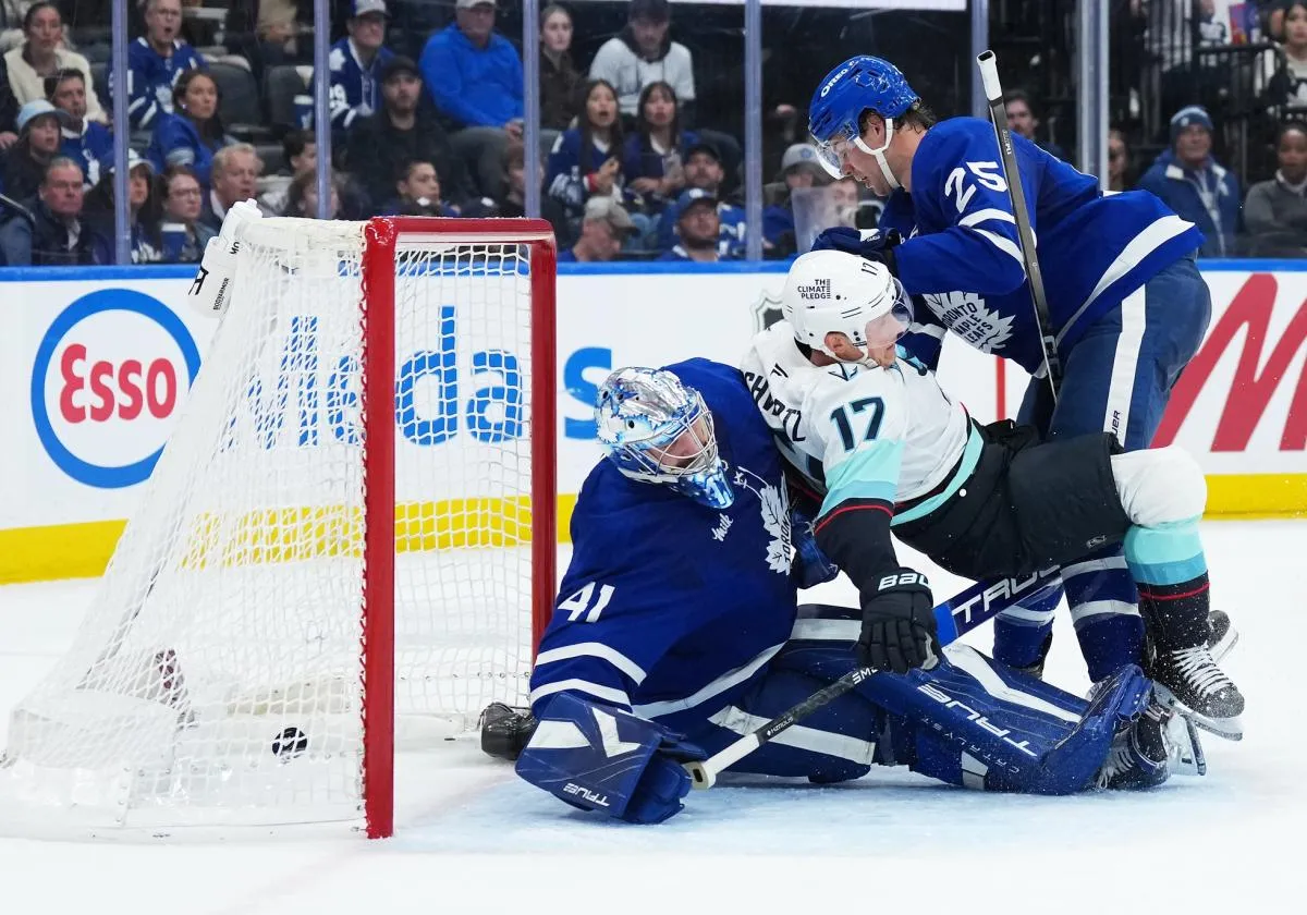 Toronto Maple Leafs defenseman Brandon Carlo (25) battles with Seattle Kraken left wing Jaden Schwartz (17) as the puck goes past goaltender Anthony Stolarz (41) for a goal during the second period at Scotiabank Arena.