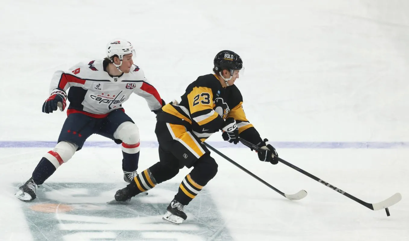 Pittsburgh Penguins defenseman Vladislav Kolyachonok (23) moves the puck against Washington Capitals right wing Ryan Leonard (9) during the third period at PPG Paints Arena.