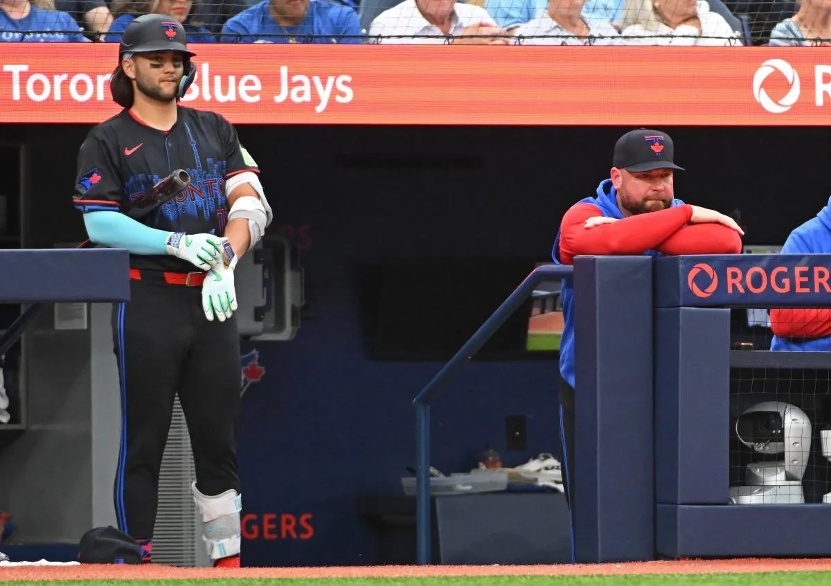 Toronto Blue Jays short stop Bo Bichette (11) and Manager John Schneider (14) in the dugout in the fourth inning against the Houston Astros at Rogers Centre.