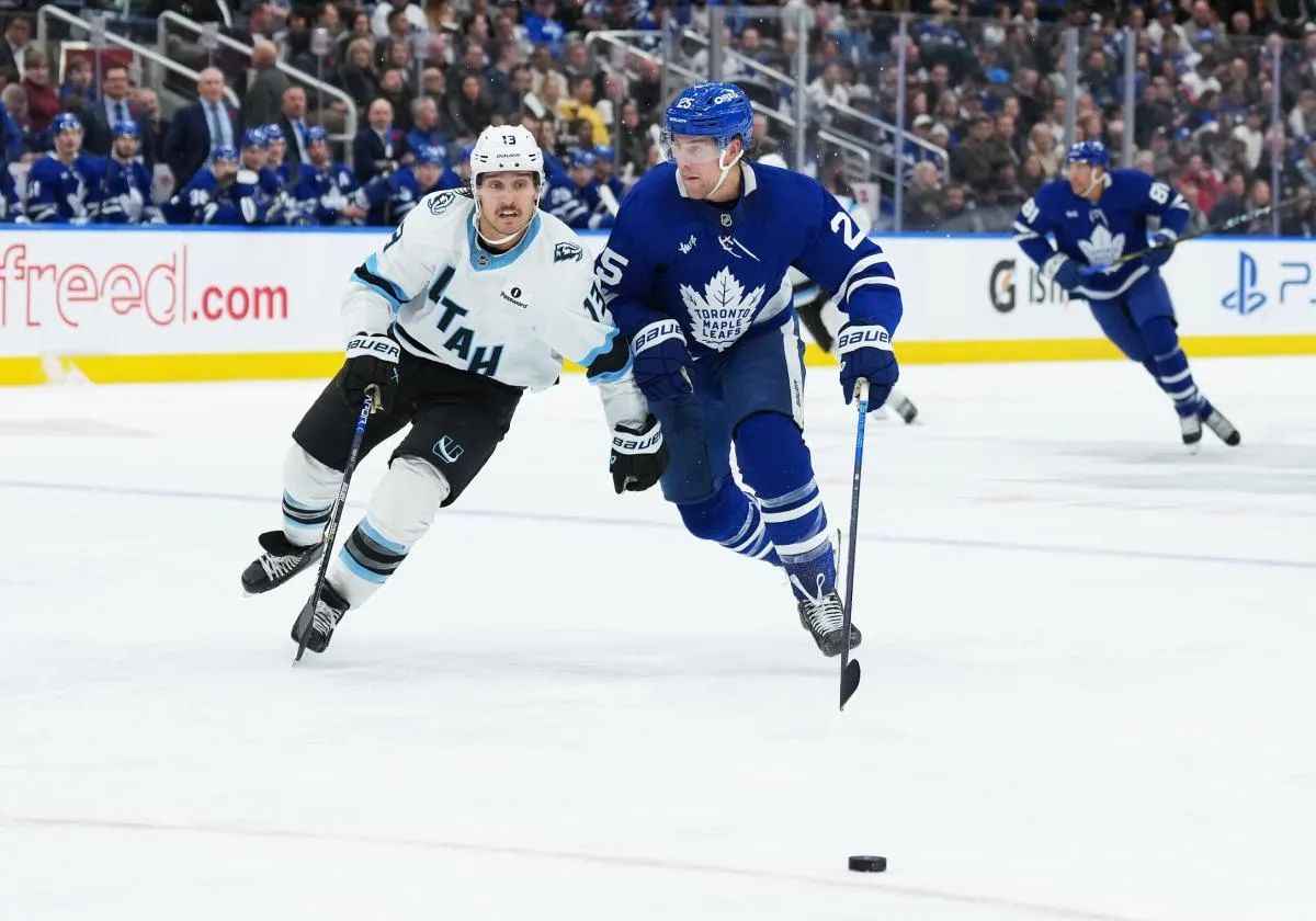 Toronto Maple Leafs defenseman Brandon Carlo (25) battles for the puck with Utah Mammoth left wing Brandon Tanev (13) during the second period at Scotiabank Arena