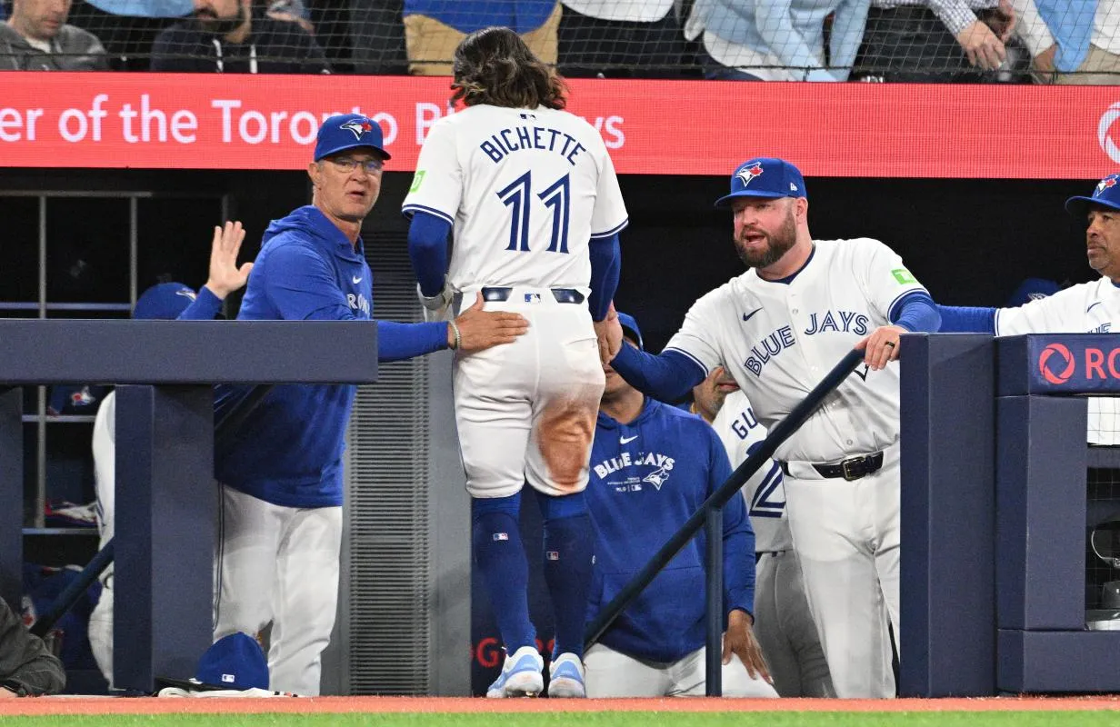 Toronto Blue Jays manager John Schneider (14) and bench coach Don Mattingly (23, left) greet shortstop Bo Bichette (11) after he scored against the Seattle Mariners in the fourth inning at Rogers Centre.