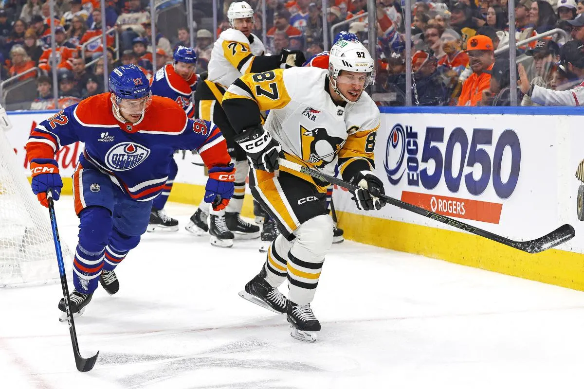 Edmonton Oilers forward Vasily Podkolzin (92) and Pittsburgh Penguins forward Sidney Crosby (87) chase a loose puck during the second period at Rogers Place.