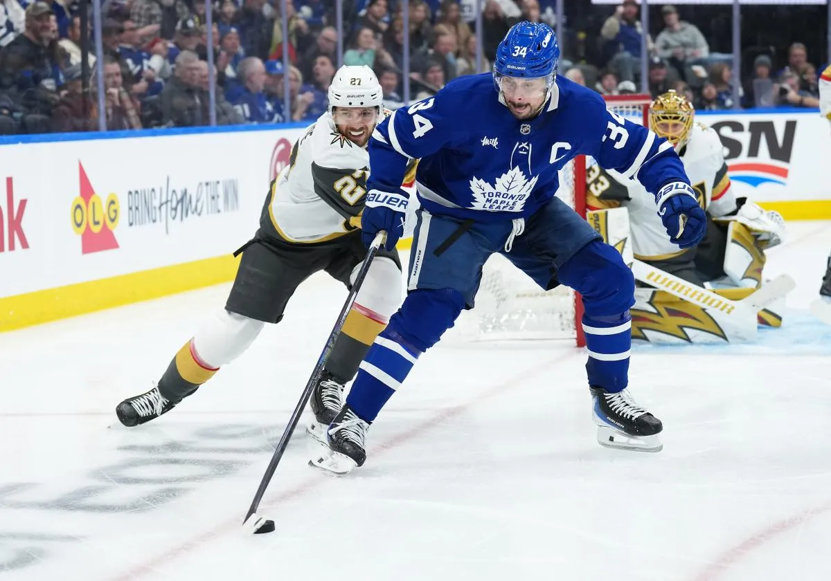 Toronto Maple Leafs center Auston Matthews (34) battles for the puck with Vegas Golden Knights defenseman Shea Theodore (27) during the third period at Scotiabank Arena.