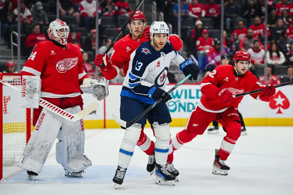 Winnipeg Jets center Gabriel Vilardi (13) and Detroit Red Wings defenseman Simon Edvinsson (77) battle for position as goaltender Alex Lyon (34) tends the net during the game at Little Caesars Arena.