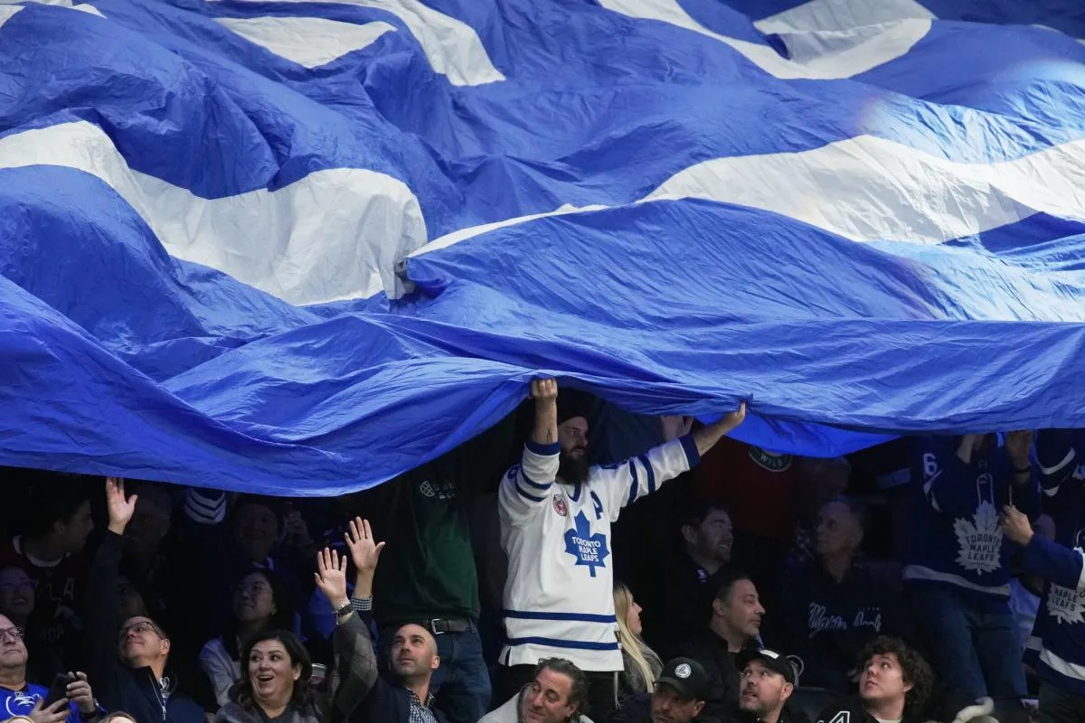 A Toronto Maple Leafs fan holds a large flag in the stands during a timeout in the third period against the Minnesota Wild at Scotiabank Arena.