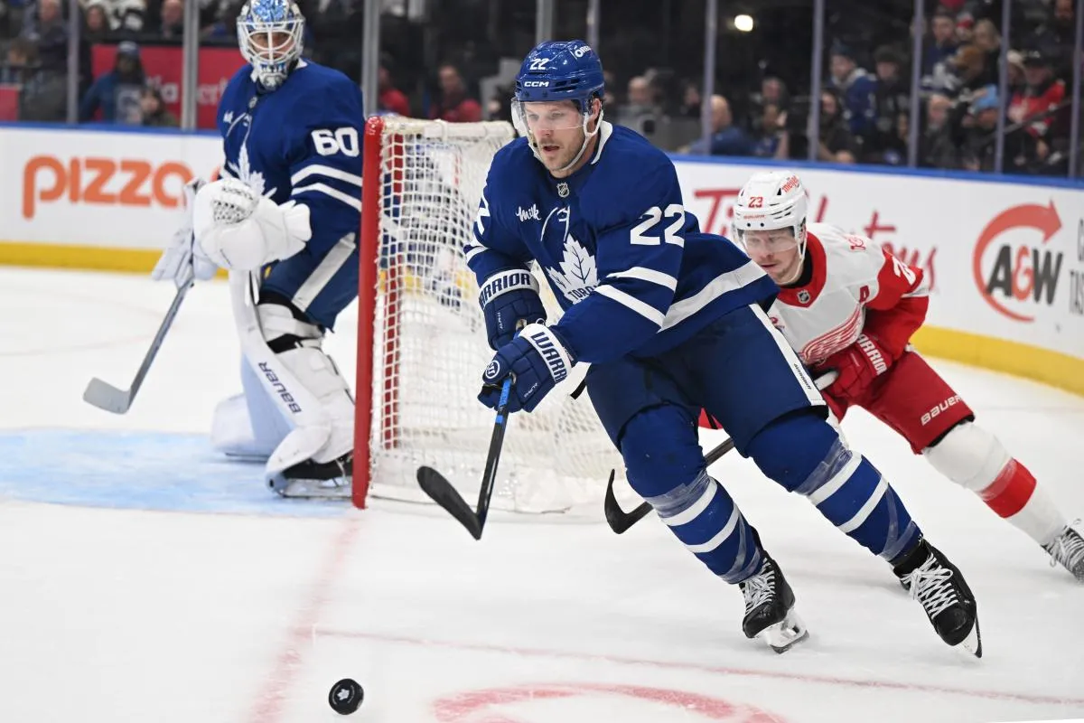 Toronto Maple Leafs defenseman Jake McCabe (22) moves the puck away from Detroit Red Wings forward Lucas Raymond (23) in the second period at Scotiabank Arena.