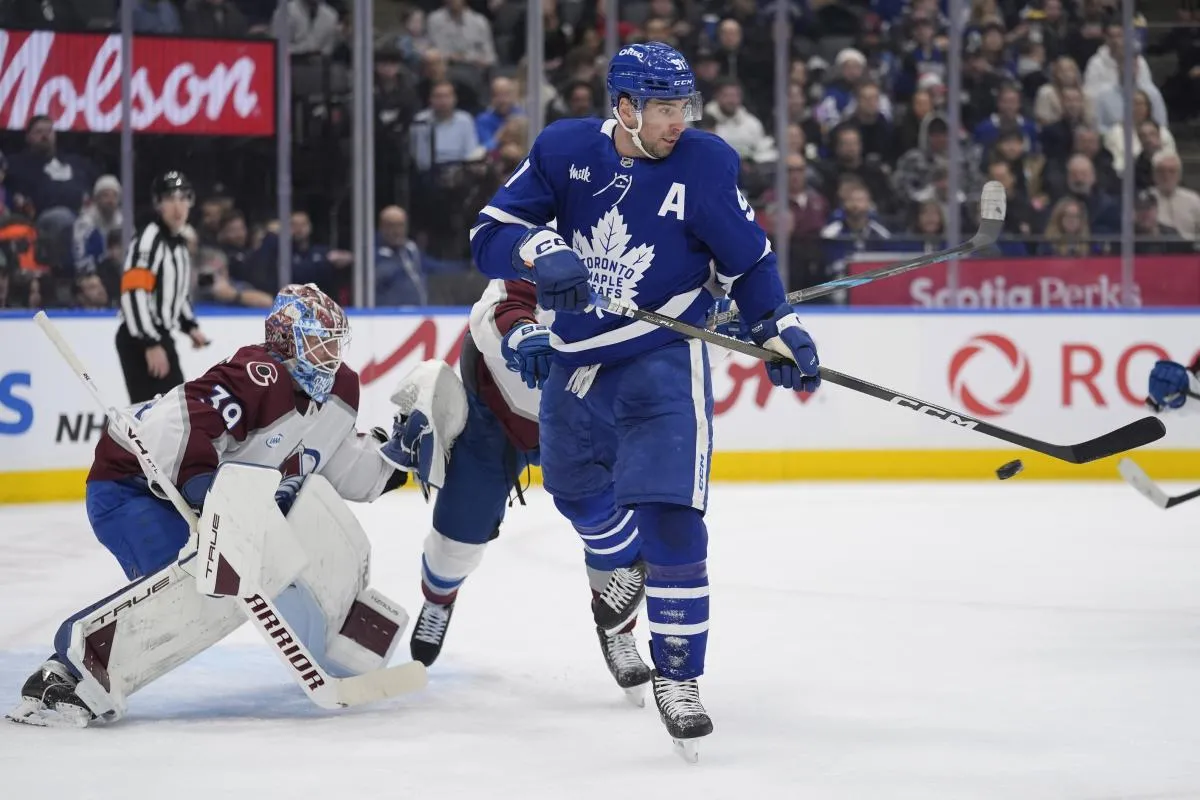 Toronto Maple Leafs forward John Tavares (91) deflects a puck at Colorado Avalanche goaltender MacKenzie Blackwood (39) during the first period at Scotiabank Arena.