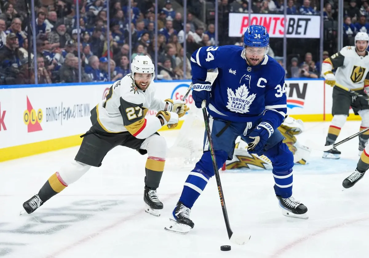 Toronto Maple Leafs center Auston Matthews (34) battles for the puck with Vegas Golden Knights defenseman Shea Theodore (27) during the third period at Scotiabank Arena.