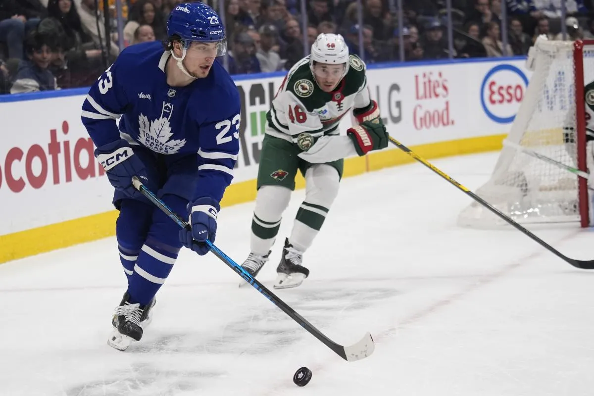 Toronto Maple Leafs forward Matthew Knies (23) plays the puck against Minnesota Wild defenseman Jared Spurgeon (46) during the first period at Scotiabank Arena.