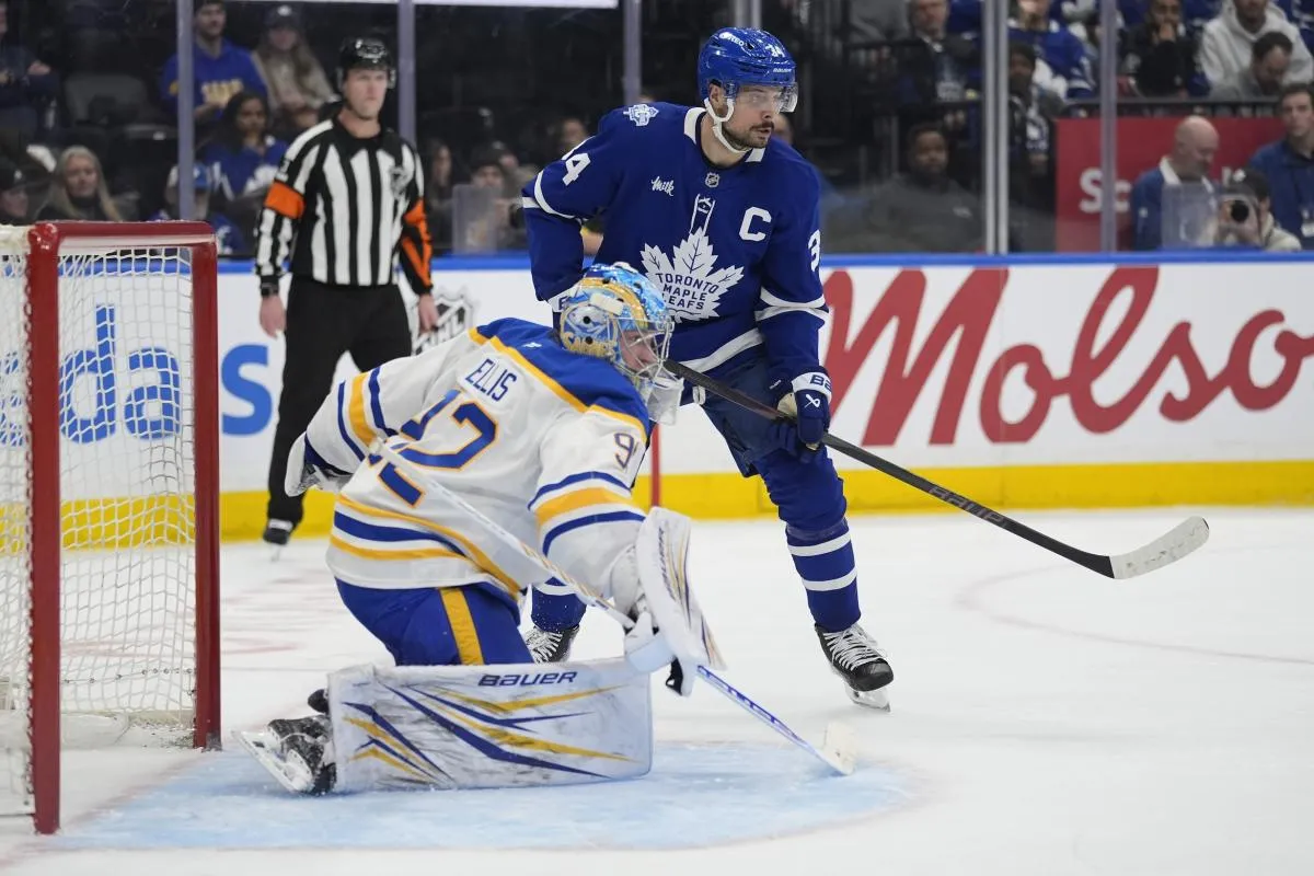 Toronto Maple Leafs forward Auston Matthews (34) and Buffalo Sabres goaltender Colten Ellis (92) look for the puck during the third period at Scotiabank Arena.