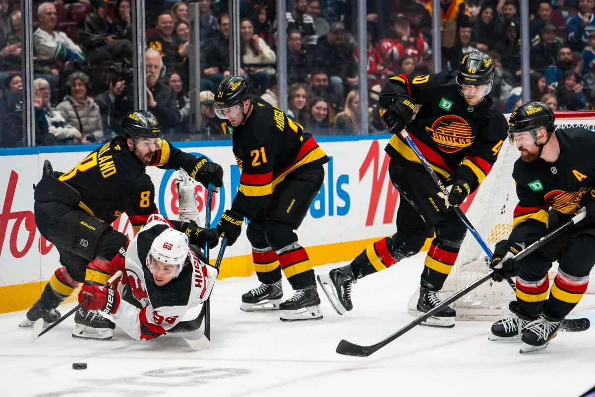 Vancouver Canucks forward Conor Garland (8) and forward Nils Hoglander (21) and forward Elias Pettersson (40) and defenseman Filip Hronek (17) battle with New Jersey Devils forward Jack Hughes (86) in the third period at Rogers Arena.
