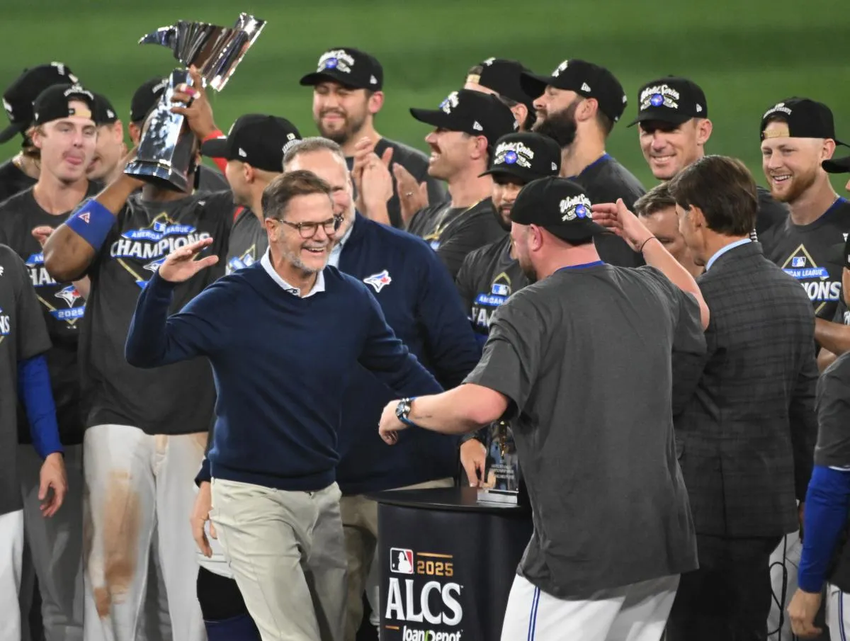 Toronto Blue Jays general manager Ross Atkins celebrates with manager John Schneider (14) after winning game seven of the ALCS round for the 2025 MLB playoffs against the Seattle Mariners at Rogers Cent