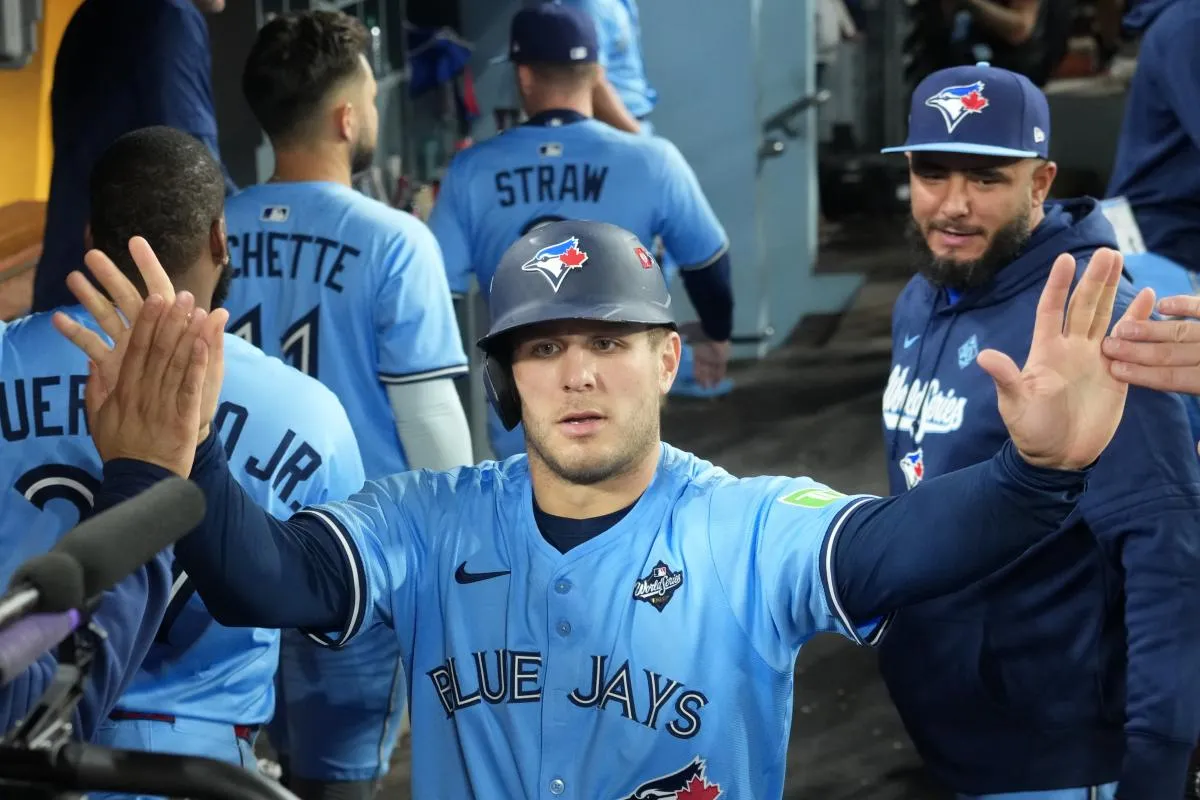 Toronto Blue Jays center fielder Daulton Varsho (5) celebrates in the dugout after scoring against the Los Angeles Dodgers in the seventh inning during game four of the 2025 MLB World Series at Dodger Stadium.