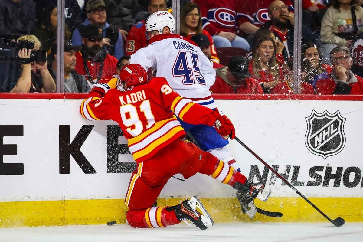 Le 8 mars 2025, &agrave; Calgary, en Alberta, Nazem Kadri (91), centre des Calgary Flames, et Alexandre Carrier (45), d&eacute;fenseur des Montr&eacute;al Canadiens, se battent pour la rondelle lors de la deuxi&egrave;me p&eacute;riode au Scotiabank Saddledome.