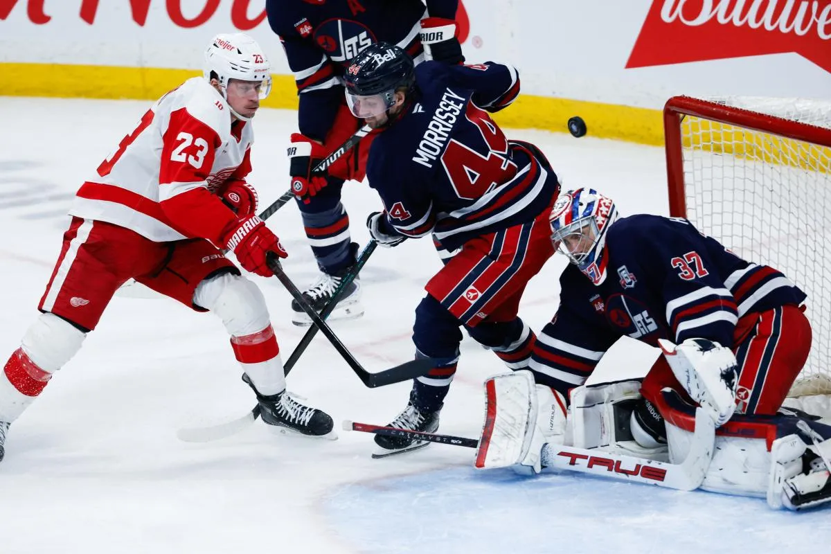 Detroit Red Wings forward Lucas Raymond (23) scores on Winnipeg Jets goalie Connor Hellebuyck (37) during the third period at Canada Life Centre.