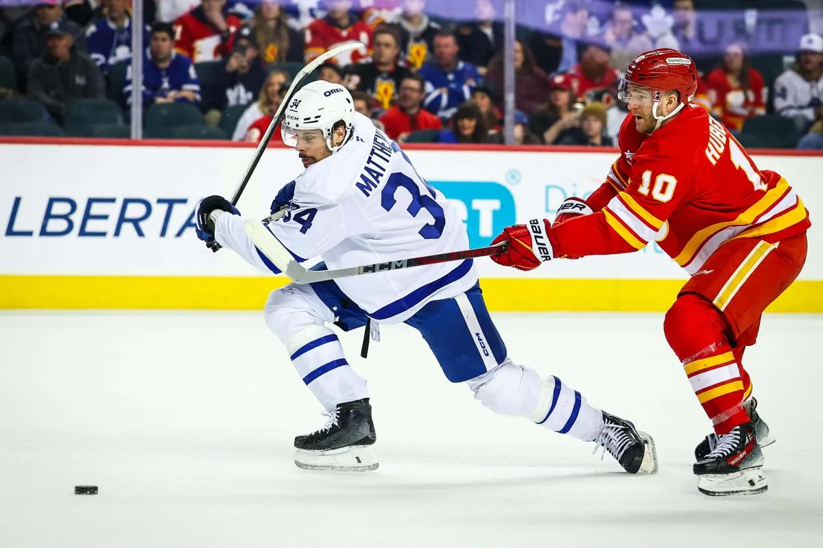 Toronto Maple Leafs center Auston Matthews (34) and Calgary Flames left wing Jonathan Huberdeau (10) battles for the puck during the third period at Scotiabank Saddledome.