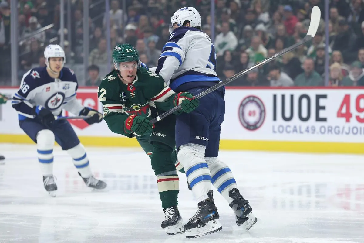 Le 15 janvier 2026, &agrave; Saint-Paul, dans le Minnesota (&Eacute;tats-Unis), l'attaquant droit du Minnesota Wild, Danila Yurov (22), tire au but tandis que le d&eacute;fenseur des Winnipeg Jets, Luke Schenn (5), le d&eacute;fend, lors du premier tiers-temps au Grand Casino Arena.