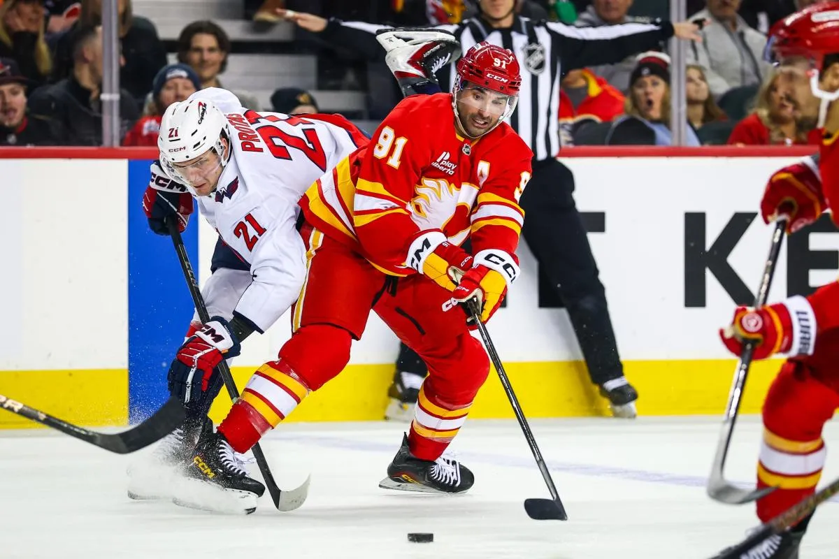 Calgary Flames center Nazem Kadri (91) and Washington Capitals center Aliaksei Protas (21) battle for the puck during the second period at Scotiabank Saddledome