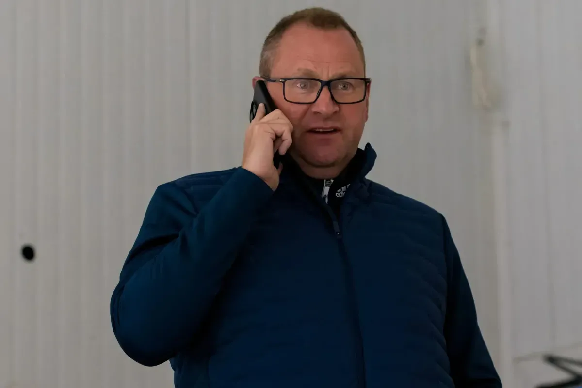 Toronto Maple Leafs GM Brad Treliving talks on the phone during an unidentified practice session.