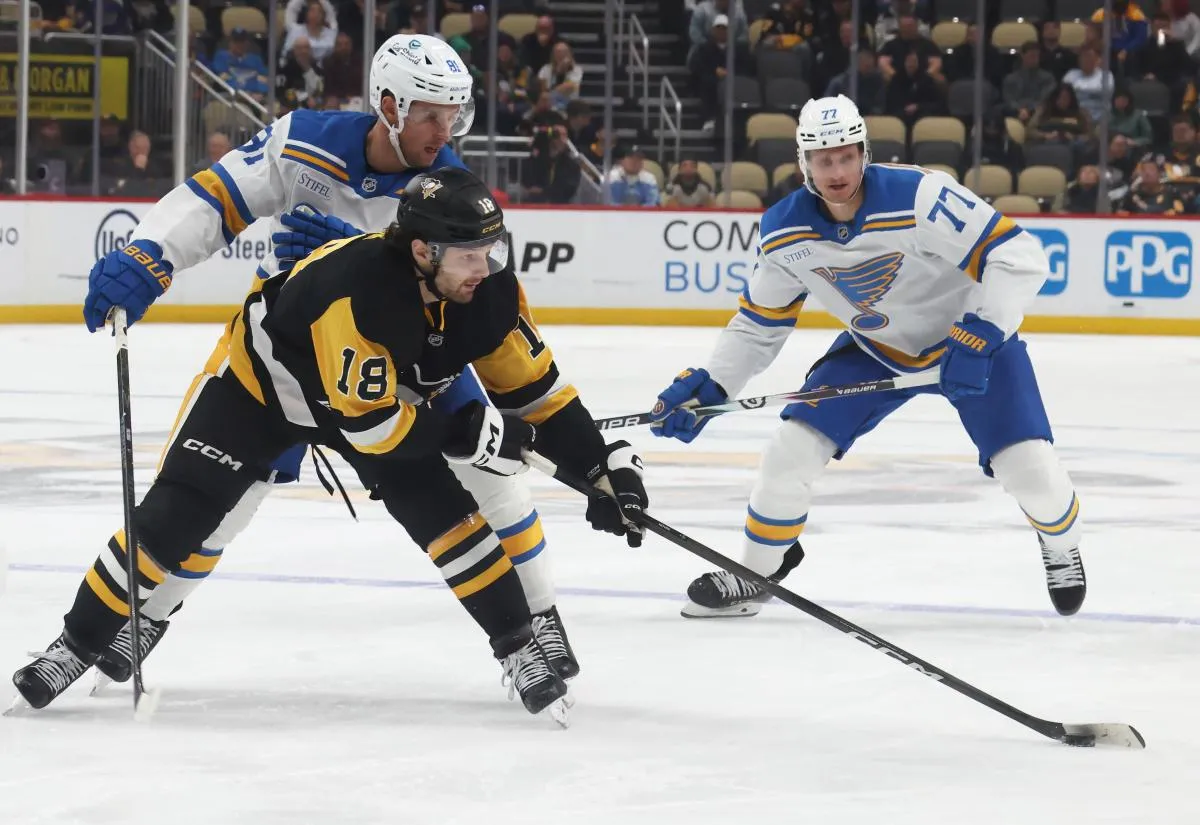 Pittsburgh Penguins center Tommy Novak (18) handles the puck against St. Louis Blues left wing Dylan Holloway (81) and center Nick Bjugstad (77) during the third period at PPG Paints Arena.