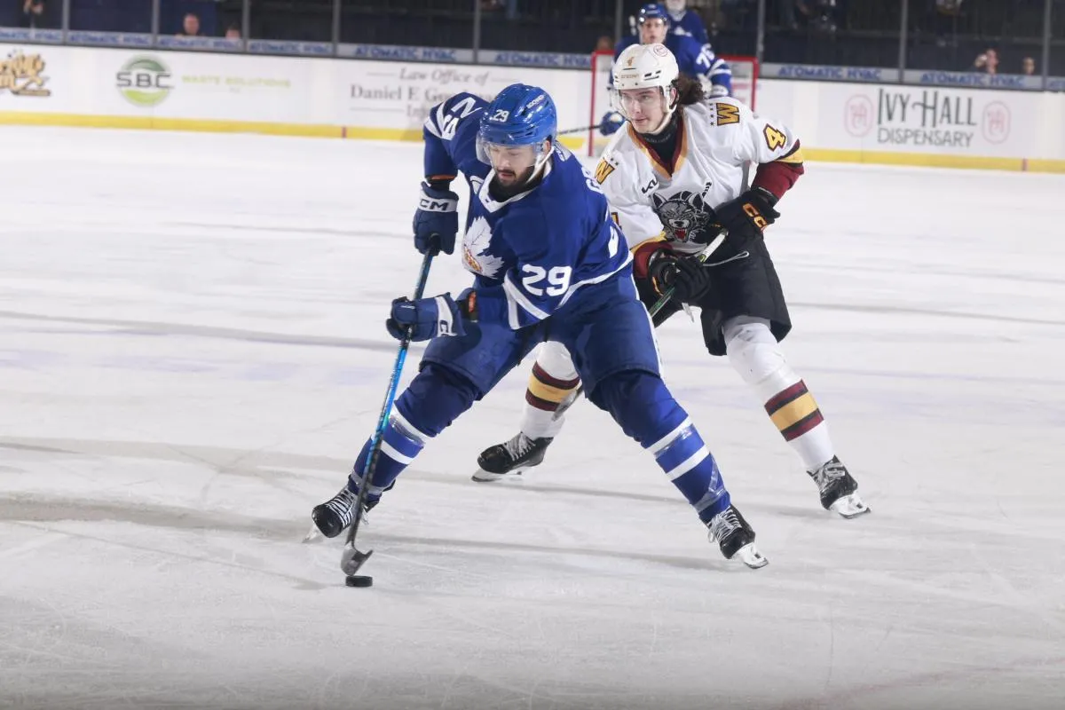 Toronto Marlies forward Benoit-Olivier Groulx controls the puck as Chicago Wolves defenceman Juuso Valimaki gives chase during an AHL game between the two clubs.