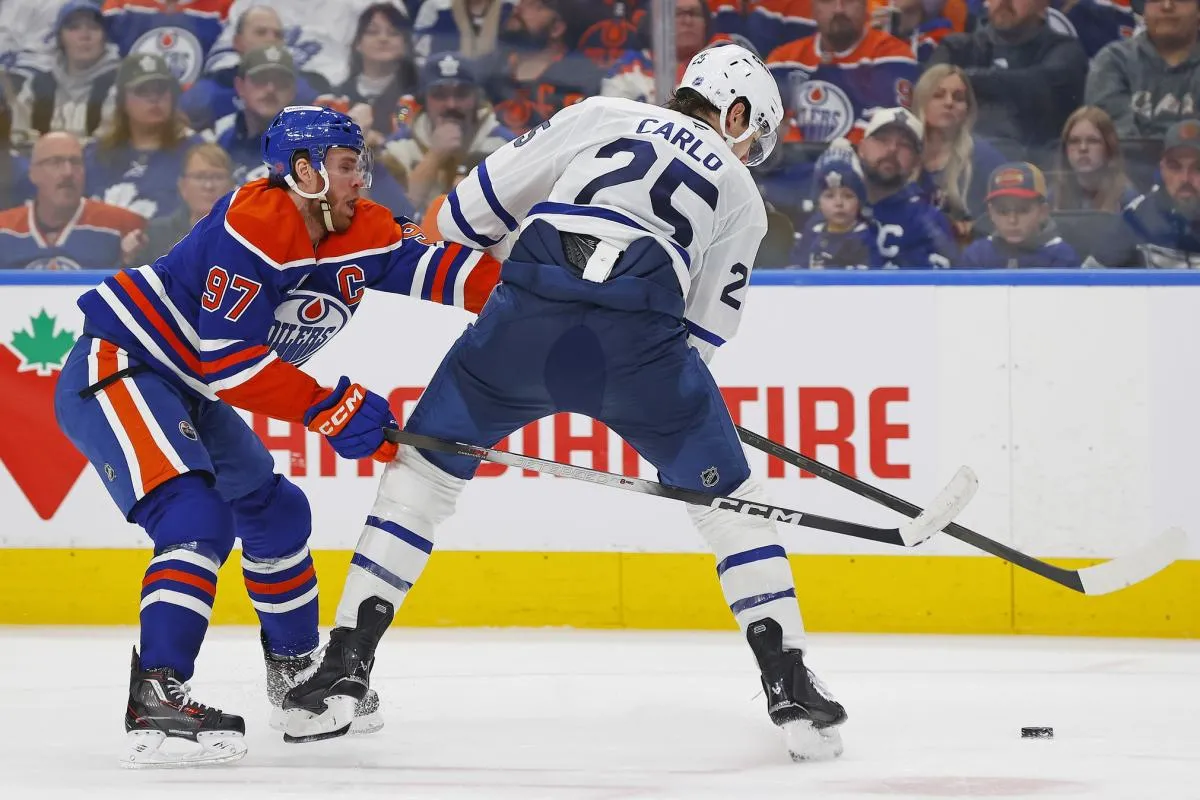 Edmonton Oilers forward Connor McDavid (97) knocks Toronto Maple Leafs defensemen Brandon Carlo (25) off the puck during the third period at Rogers Place.