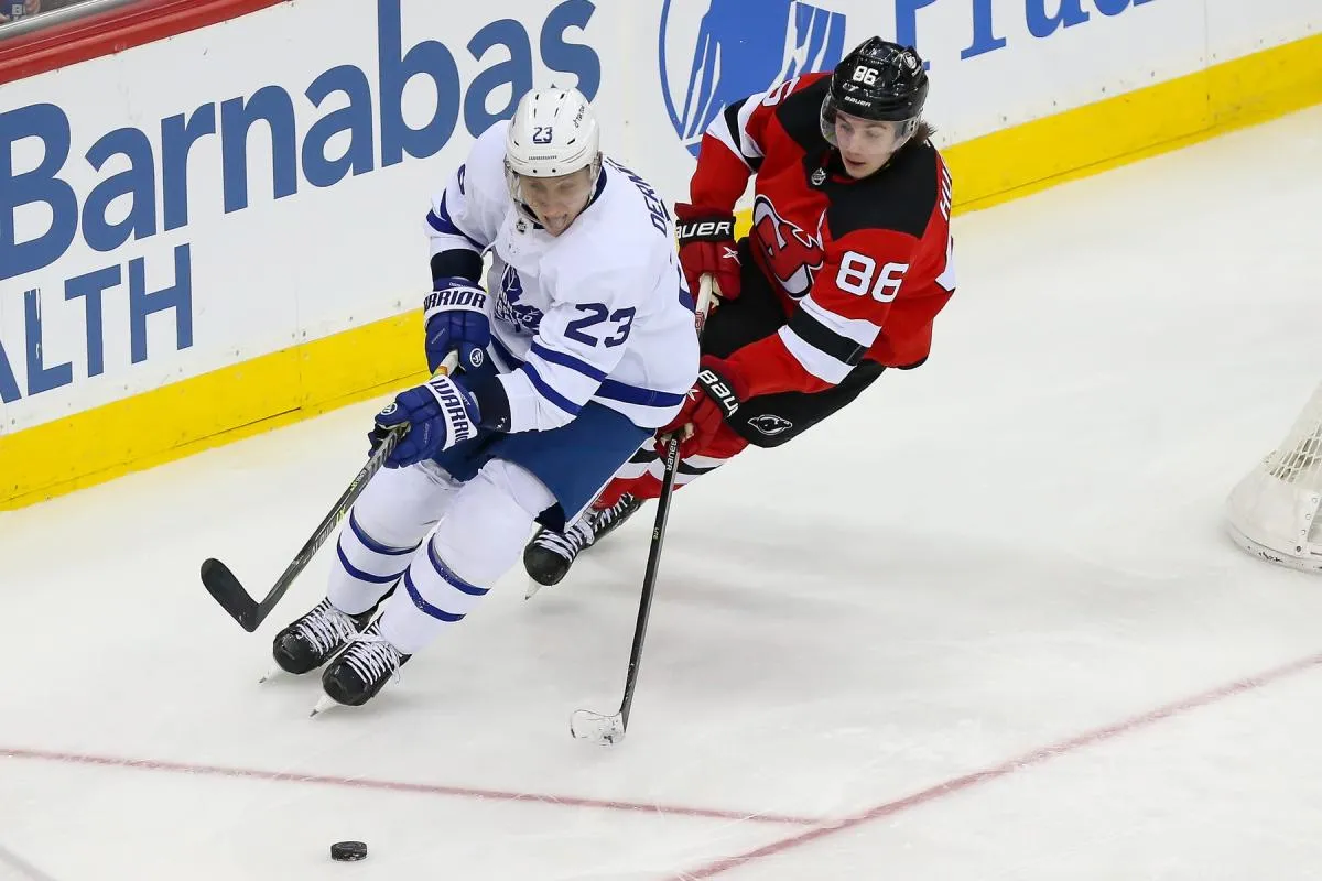 Toronto Maple Leafs defenseman Travis Dermott (23) moves the puck past New Jersey Devils center Jack Hughes (86) during the third period at Prudential Center.