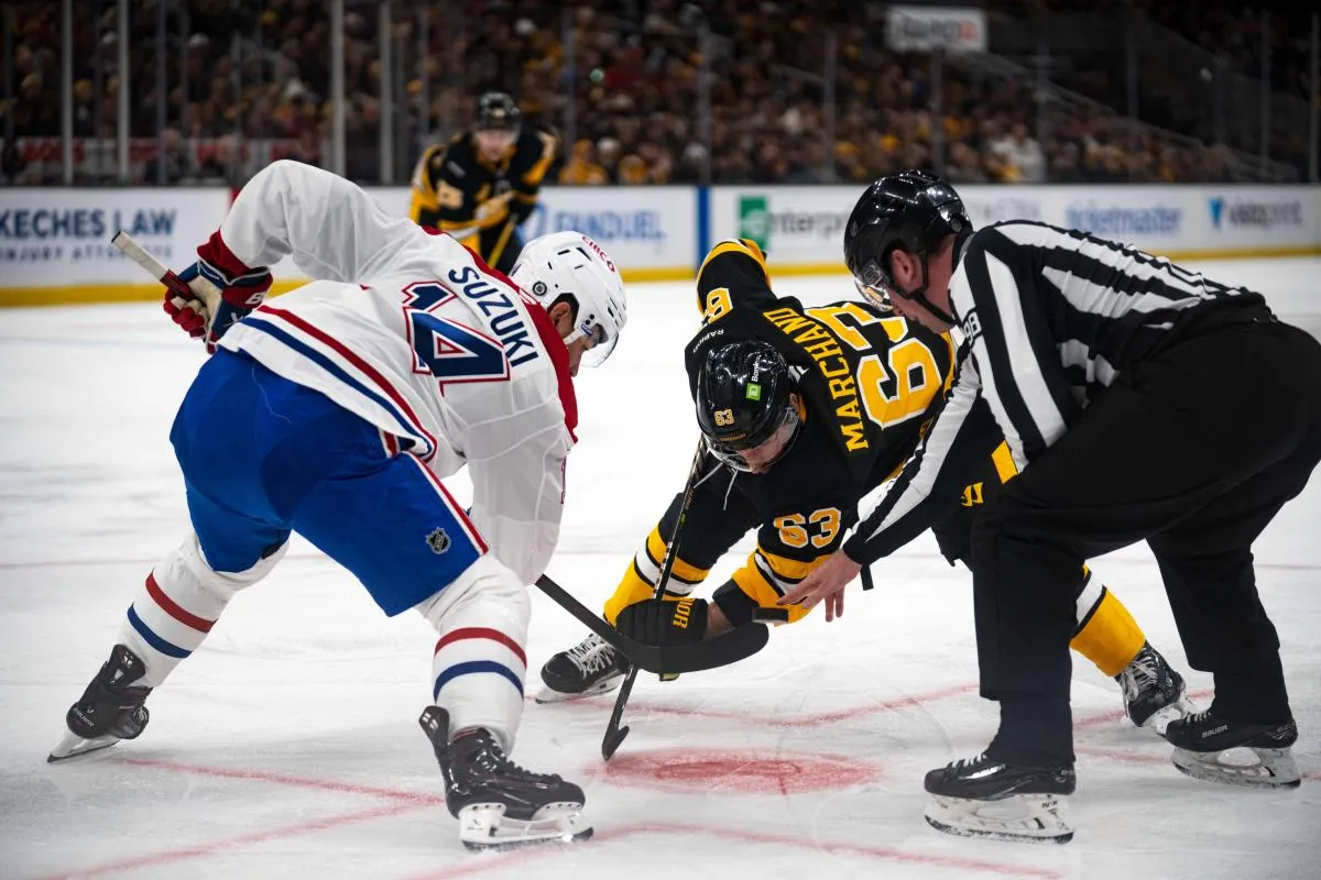 Brad Marchand (63), ailier gauche des Bruins de Boston, et Nick Suzuki (14), centre des Canadiens de Montr&eacute;al, s'affrontent lors d'une mise au jeu au cours de la premi&egrave;re p&eacute;riode d'un match disput&eacute; au TD Garden.
