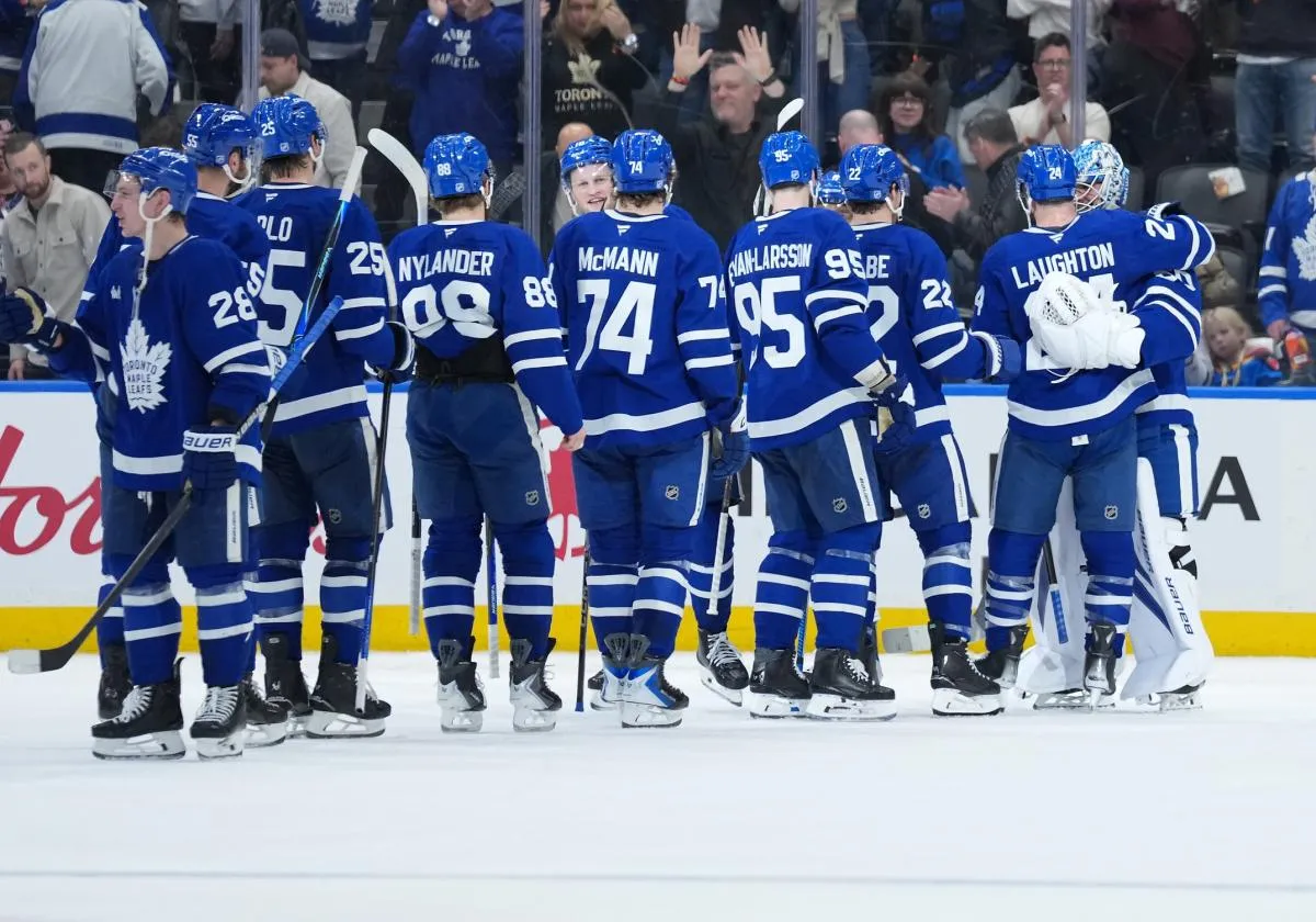 Toronto Maple Leafs goaltender Joseph Woll (60) celebrates the win with center Scott Laughton (24) against the Vancouver Canucks at the end of the third period at Scotiabank Arena.