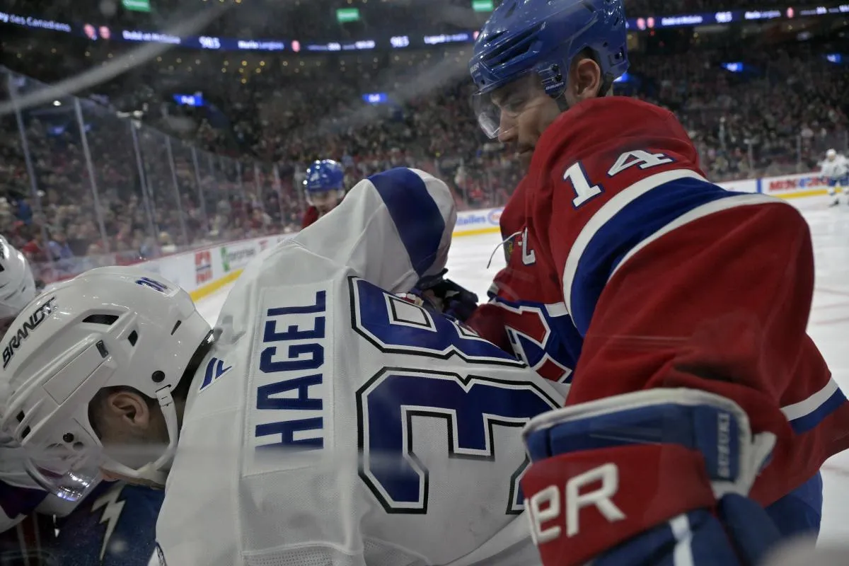 L'attaquant des Canadiens de Montr&eacute;al Nick Suzuki (14) charge l'attaquant du Lightning de Tampa Bay Brandon Hagel (38) pendant la premi&egrave;re p&eacute;riode au Centre Bell.