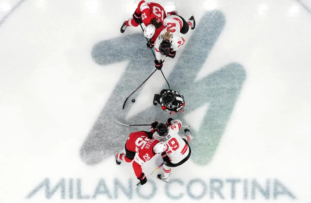Marie-Philip Poulin (Canada) face &agrave; Alina Muller (Suisse), Natalie Spooner (Canada) et Ivana Wey (Suisse) lors d'une mise au jeu en deuxi&egrave;me p&eacute;riode du groupe A de hockey sur glace f&eacute;minin des Jeux olympiques d'hiver de Milan-Cortina 2026 &agrave; la patinoire de Milan-Rho.