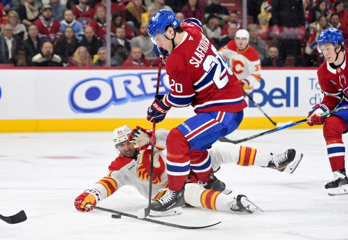 L'attaquant des Canadiens de Montr&eacute;al Juraj Slafkovsky (20) joue la rondelle et l'attaquant des Flames de Calgary Nazem Kadri (91) d&eacute;fend pendant la deuxi&egrave;me p&eacute;riode au Centre Bell.