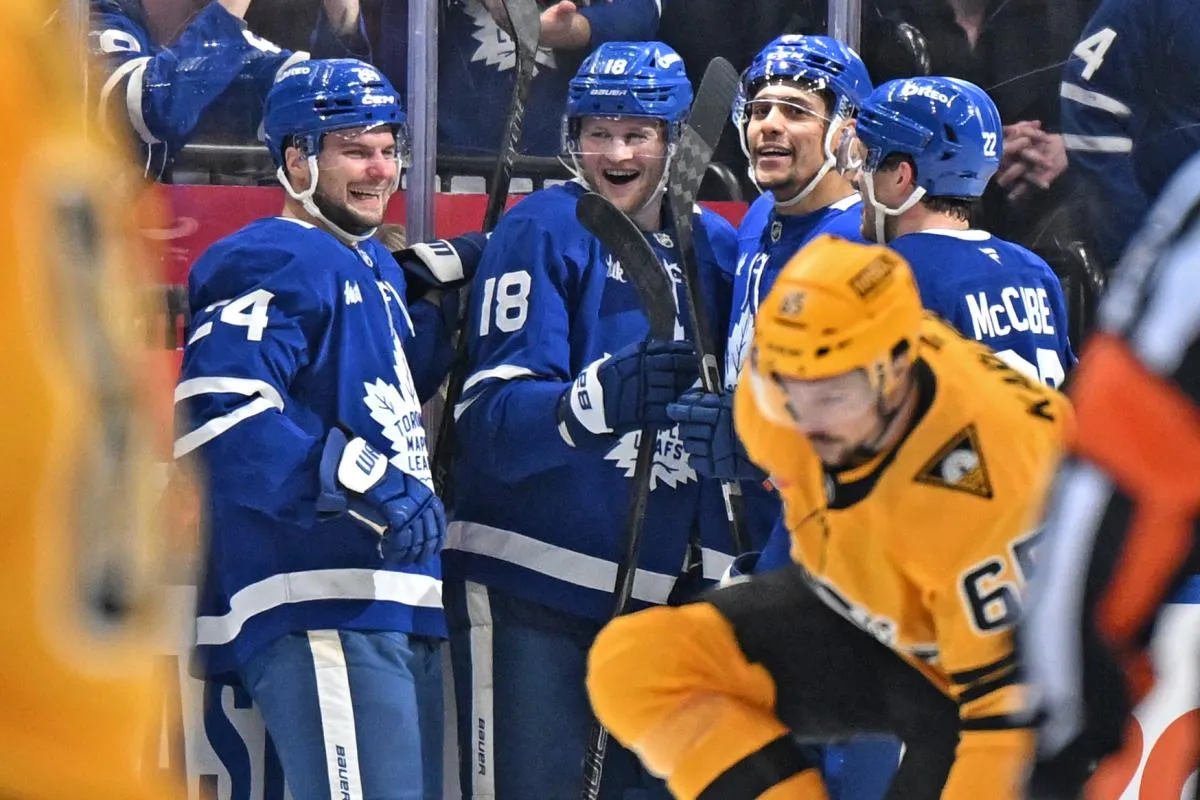 Toronto Maple Leafs forward Steven Lorentz (18) celebrates with forwards Scott Laughton (24) and Dakota Joshua (81) and defenseman Jake McCabe (22) after scoring a goal against the Pittsburgh Penguins in the second period at Scotiabank Arena.