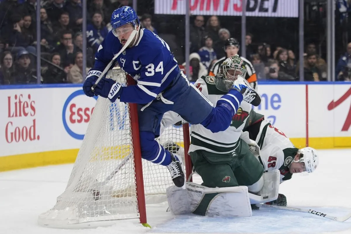 Toronto Maple Leafs forward Auston Matthews (34) collides with the net after shooting the puck against Minnesota Wild goaltender Filip Gustavsson (32) and defenseman Daemon Hunt (48) during the first period at Scotiabank Arena.