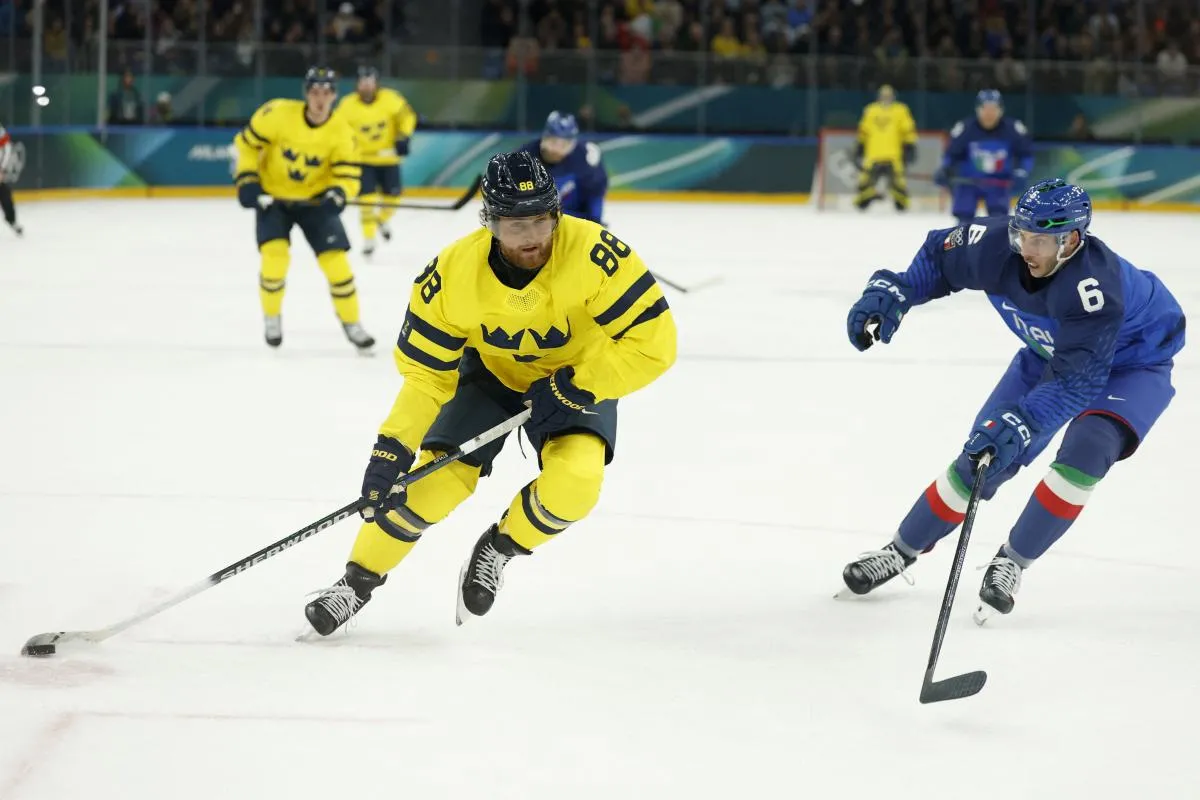 William Nylander of Sweden in action with Jason Seed of Italy in men's ice hockey group B play during the Milano Cortina 2026 Olympic Winter Games at Milano Santagiulia Ice Hockey Arena.
