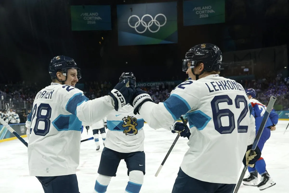 Eeli Tolvanen of Finland celebrates scoring their first goal with Artturi Lehkonen of Finland against Slovakia in men's ice hockey group B play during the Milano Cortina 2026 Olympic Winter Games at Milano Santagiulia Ice Hockey Arena.