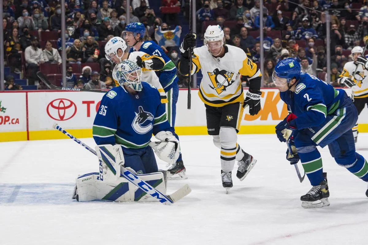 Vancouver Canucks goalie Thatcher Demko (35) and defenseman Luke Schenn (2) look on as Pittsburgh Penguins forward Jeff Carter (77) celebrates a goal scored by forward Jake Guentzel (59) in the second period at Rogers Arena.