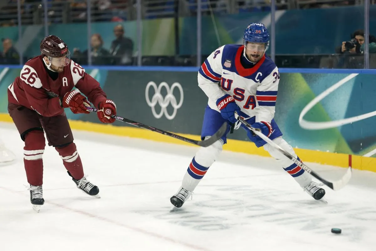 Auston Matthews of United States in action with Uvis Janis Balinskis of Latvia in men's ice hockey group C play during the Milano Cortina 2026 Olympic Winter Games at Milano Santagiulia Ice Hockey Arena.