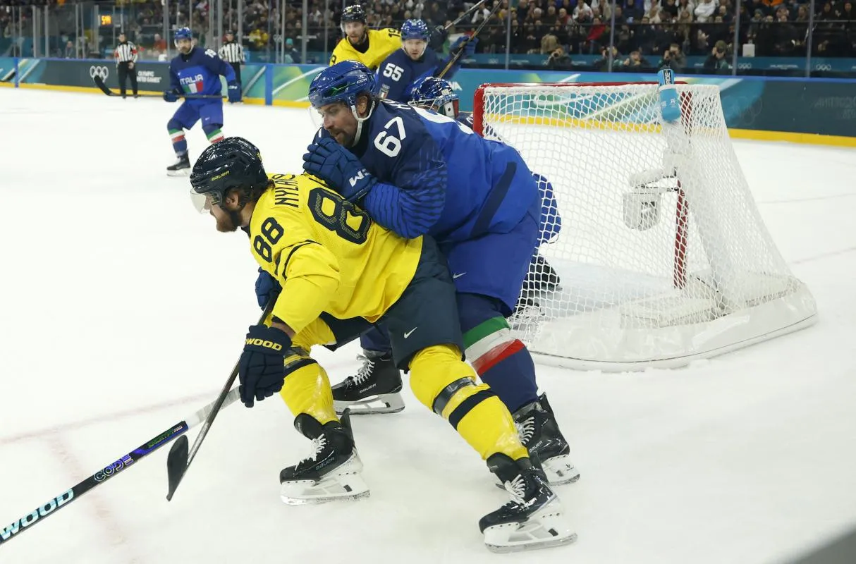 William Nylander of Sweden in action with Mats Frycklund of Italy in men's ice hockey group B play during the Milano Cortina 2026 Olympic Winter Games at Milano Santagiulia Ice Hockey Arena.