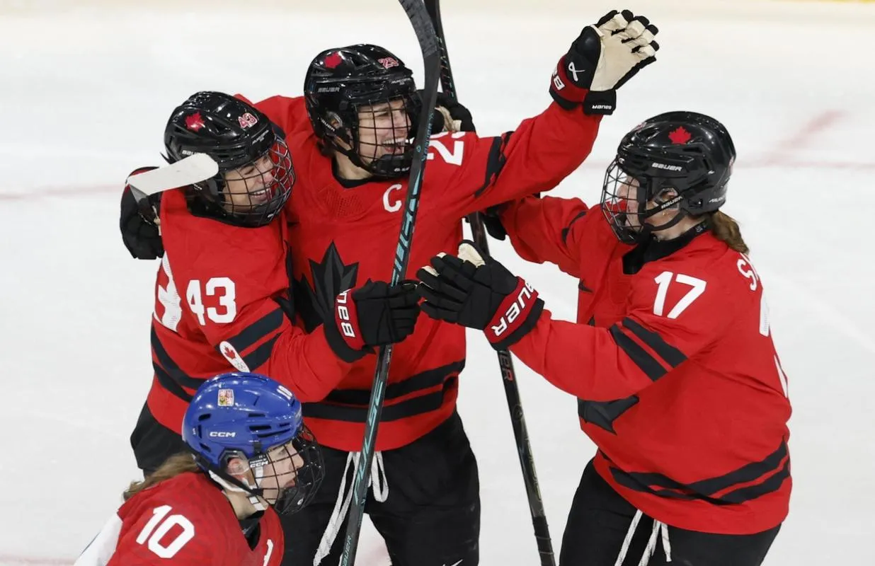 Kristin O'Neill of Canada celebrates scoring their first goal with Marie-Philip Poulin of Canada and Ella Shelton of Canada against Czechia in women's ice hockey group B play during the Milano Cortina 2026 Olympic Winter Games at Milano Rho Ice Hockey Arena.
