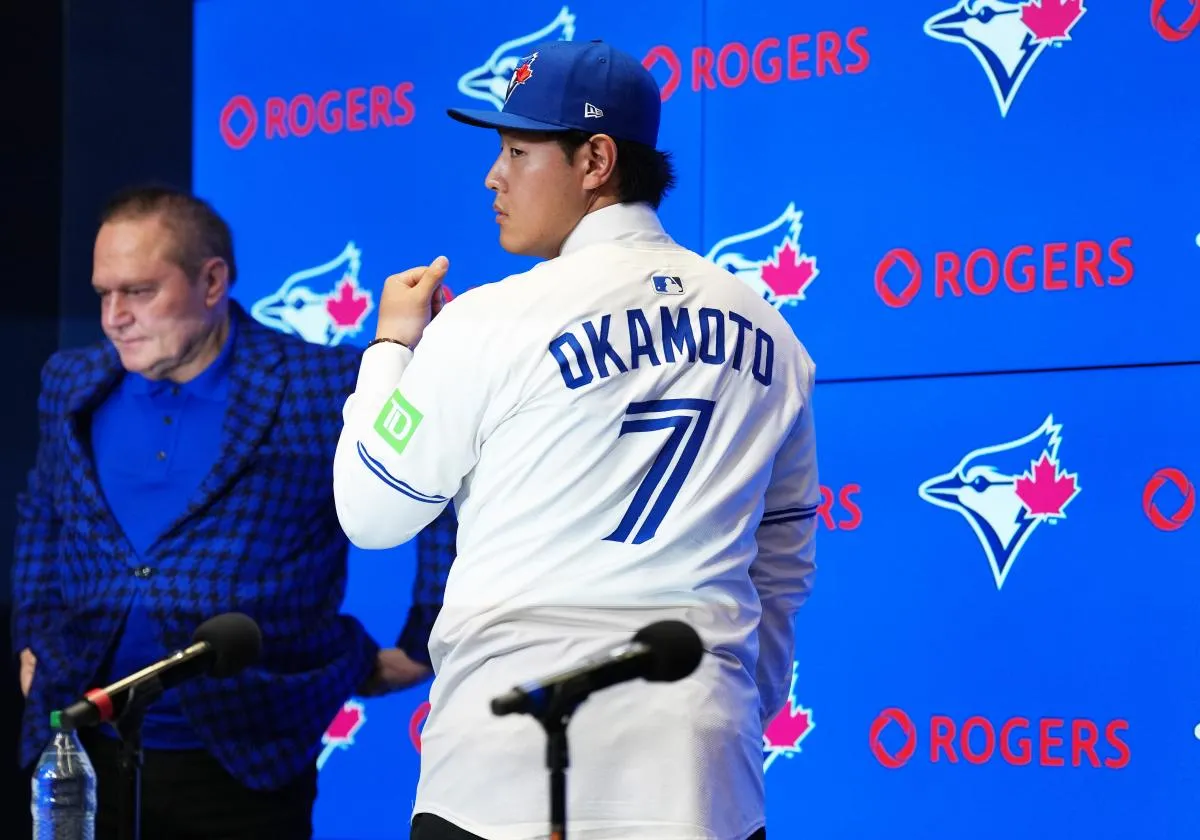Toronto Blue Jays Kazuma Okamoto stands up to show the back of his jersey to the media during the press conference at Rogers Centre.