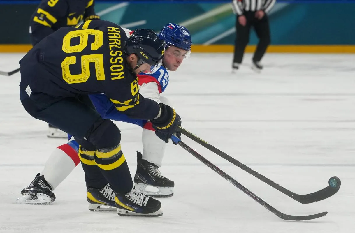 Erik Karlsson of Sweden in action with Dalibor Dvorsky of Slovakia during a Group B men's ice hockey game during the Milano Cortina 2026 Olympic Winter Games at Milano Santagiulia Ice Hockey Arena.