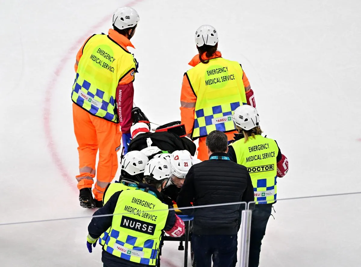 Kevin Fiala of Switzerland is taken off the ice by medical staff on a stretcher after sustaining an injury against Canada in men's ice hockey group A play during the Milano Cortina 2026 Olympic Winter Games at Milano Santagiulia Ice Hockey Arena.