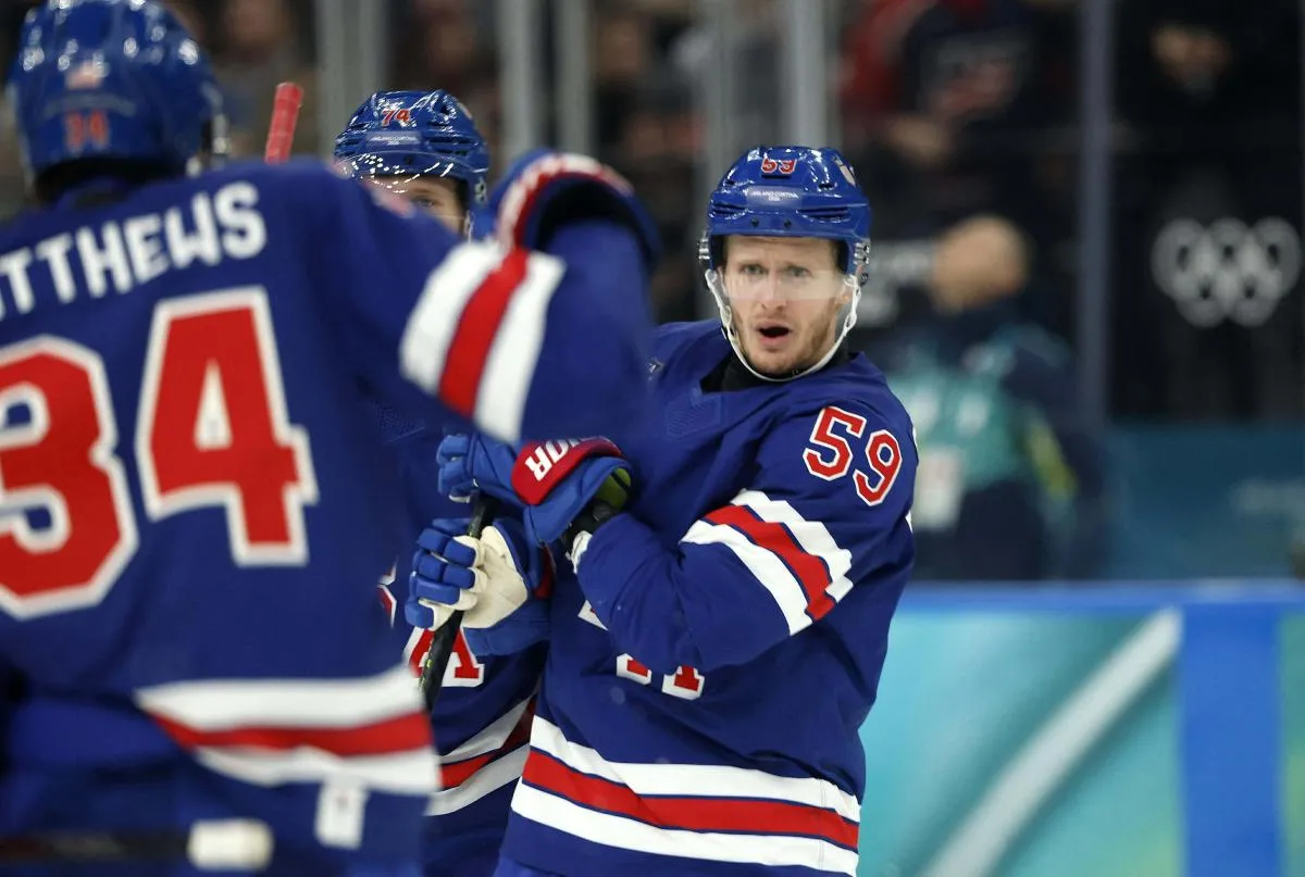Jake Guentzel of United States celebrates scoring their fifth goal with Jaccob Slavin of United States and Auston Matthews of United States against Denmark in men's ice hockey group C play during the Milano Cortina 2026 Olympic Winter Games at Milano Santagiulia Ice Hockey Arena.