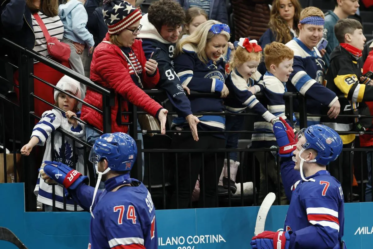 Jaccob Slavin of United States and Brady Tkachuk of United States greet spectators at the end of the match against Denmark in men's ice hockey group C play during the Milano Cortina 2026 Olympic Winter Games at Milano Santagiulia Ice Hockey Arena.