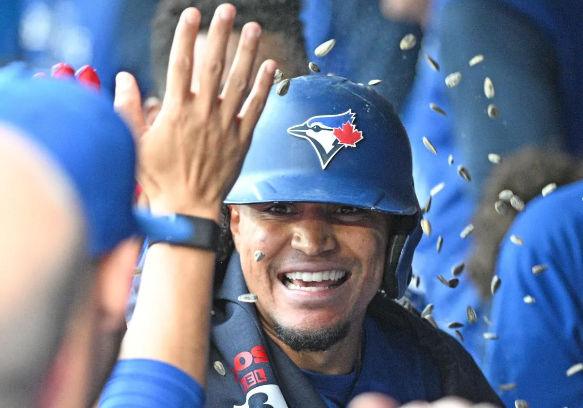Toronto Blue Jays second baseman Santiago Espinal (5) is greeted by team mates in the dugout after hitting a solo home run against the Chicago White Sox in the first inning at Rogers Centre.