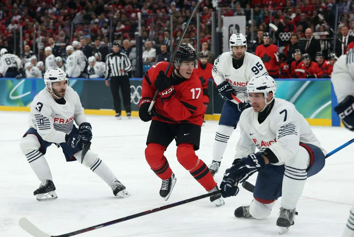 Macklin Celebrini of Canada in action with Pierre Crinon of France in men's ice hockey group A play during the Milano Cortina 2026 Olympic Winter Games at Milano Santagiulia Ice Hockey Arena.